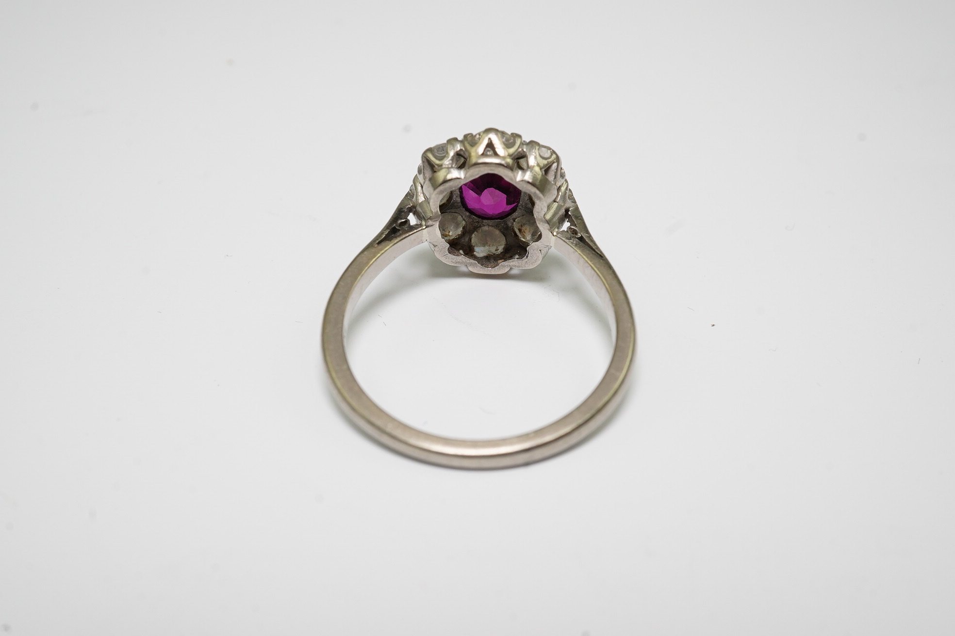 An 18ct white gold, ruby and diamond set oval cluster ring